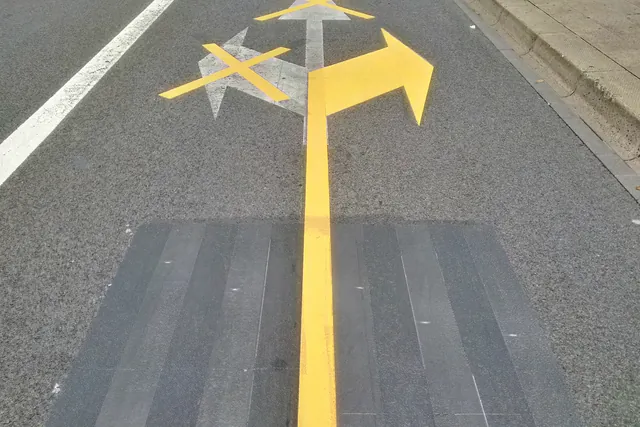 Marka panah kuning di permukaan jalan aspal